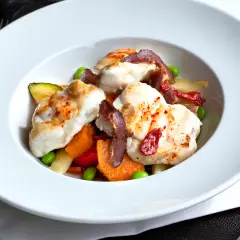 Délicieuse lotte poêlée, servie avec des légumes croquants et des tomates séchées. Un plat savoureux et coloré.