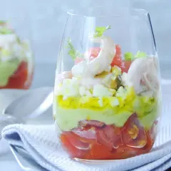 Verrine avocat crevette : couches de tomates, avocat crémeux, œuf dur et crevettes roses, garnie de coriandre. Un délice frais.