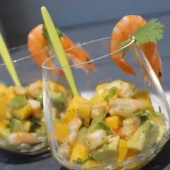 Verrine avocat saumon : deux coupes remplies d'un mélange coloré d'avocat, de mangue et de crevettes, garnies d'une crevette et d'une feuille de coriandre.