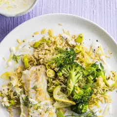 Poisson blanc avec riz, brocolis et poireaux, arrosé d'une sauce aneth crémeuse et garni de citron.
