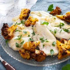 Délicieux poisson aiglefin poêlé, servi avec du chou-fleur rôti et garni de persil frais.