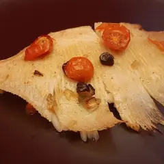 Aile de raie cuite à l'eau, garnie de tomates cerises et d'olives. Le temps de cuisson est parfait pour cette recette.