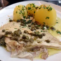 Une aile de raie à la plancha, servie avec des pommes de terre vapeur et une sauce aux câpres et persil. Un plat savoureux et léger.