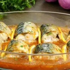 Maquereaux au four, tendres et savoureux, baignant dans une sauce tomate parfumée, accompagnés de quartiers de citron.