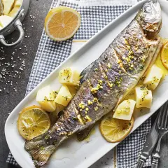 Poisson entier au barbecue, garni de citron et de pommes de terre. Un délice simple et savoureux.