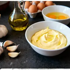 Préparation de la recette aïoli grand-mère : ail, œufs, huile d'olive et une belle mayonnaise crémeuse.