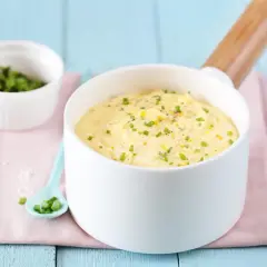 Un bol de beurre citronné (pour poisson) garni de ciboulette et de zeste de citron, prêt à sublimer votre plat.