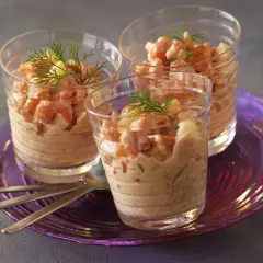 Trois verrines garnies de crevettes et d'une onctueuse sauce cocktail, décorées d'aneth.