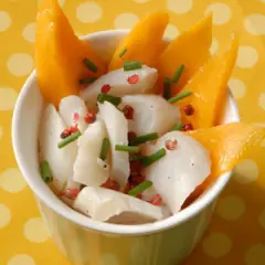 Délicieuse recette cabillaud enfant : morceaux de poisson blanc, mangue fraîche, ciboulette et poivre rose dans un bol.