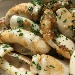 Délicieuse seiche à la plancha, dorée et parsemée de persil frais. Un plat simple et savoureux.