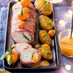 Lotte enroulée de lard, servie avec des pommes de terre Hasselback et une sauce pour lotte au lard onctueuse.