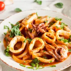 Délicieuse cuisson lamelle d'encornet à la poêle, garnie de persil frais. Un plat savoureux et coloré.