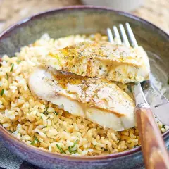 Deux filets de poisson blanc, assaisonnés et servis sur un lit de riz. Le lieu noir est-il un bon poisson ? Oui, il est délicieux ainsi !
