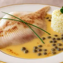 Délicieuse recette raie à la poêle, servie avec du riz et une sauce crémeuse aux câpres.