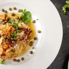 Délicieuse aile de raie poêlée, nappée d'une sauce citronnée et garnie de câpres et de persil frais. Un plat savoureux et léger.