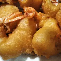 Gros plan sur des beignets de crevette dorés et croustillants, prêts à être dégustés.