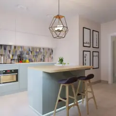 Cuisine moderne avec îlot central, tabourets et un bar à poisson mural.