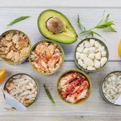 Six boîtes de crabe préparé pour la cuisson, avec avocat, tomate jaune et oignons verts.