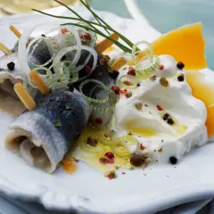 Délicieuse rollmops recette : harengs roulés, oignons, fromage et crème, assaisonnés de poivre et d'herbes.