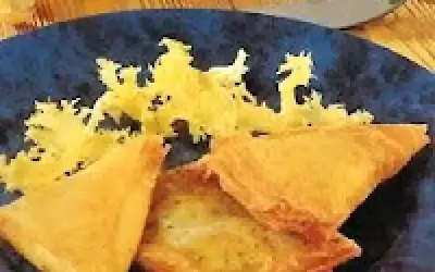 Délicieuse recette brick thon pomme de terre, croustillante et dorée, servie sur une assiette bleue avec une garniture jaune.