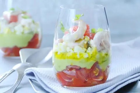Verrine avocat crevette : couches de tomates, avocat crémeux, œuf dur et crevettes roses, garnie de coriandre. Un délice frais.