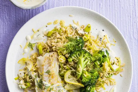 Poisson blanc avec riz, brocolis et poireaux, arrosé d'une sauce aneth crémeuse et garni de citron.