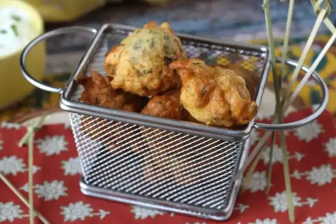 Accras de morue antillais dorés et croustillants dans une petite friteuse. Parfait pour une recette antillaise.