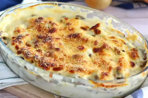 Un délicieux gratin de poisson crémeux, doré au four avec du fromage râpé, prêt à être dégusté.