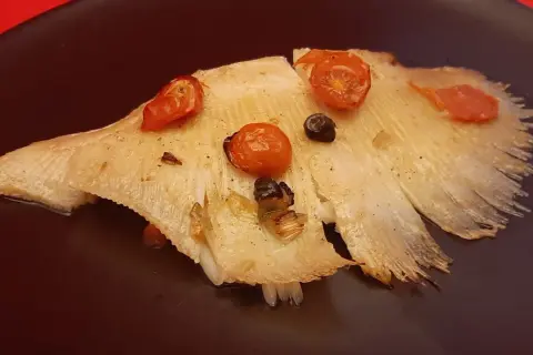 Aile de raie cuite à l'eau, garnie de tomates cerises et d'olives. Le temps de cuisson est parfait pour cette recette.