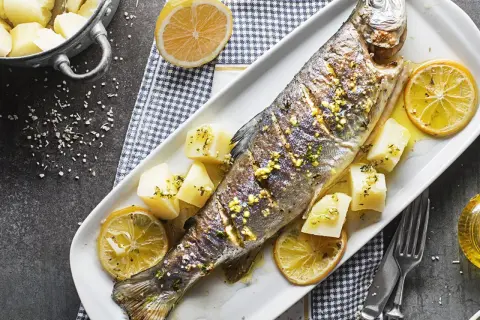 Poisson entier au barbecue, garni de citron et de pommes de terre. Un délice simple et savoureux.