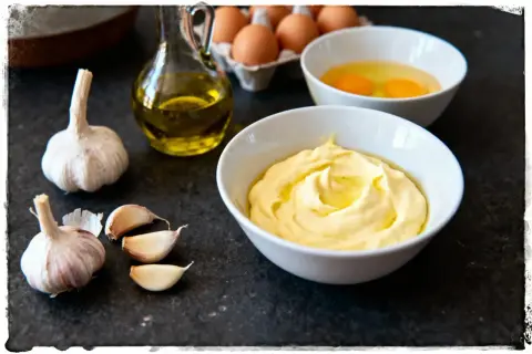 Préparation de la recette aïoli grand-mère : ail, œufs, huile d'olive et une belle mayonnaise crémeuse.