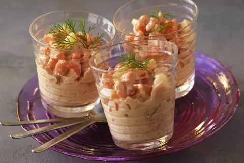 Trois verrines garnies de crevettes et d'une onctueuse sauce cocktail, décorées d'aneth.