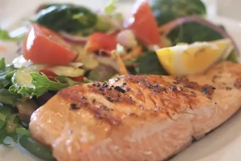 Un délicieux filet de saumon grillé, parfaitement assaisonné, servi avec une salade fraîche et colorée. Un accompagnement poisson idéal pour un repas léger et savoureux.