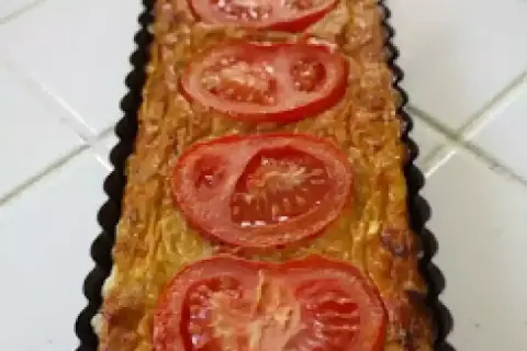 Quiche rectangulaire garnie de thon, tomate et moutarde, prête à être dégustée.