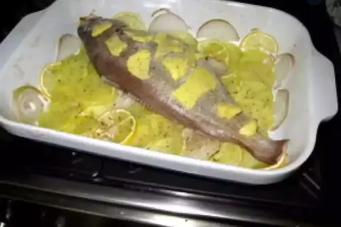 Poisson entier préparé pour la cuisson, avec des rondelles de citron et d'oignon. Une belle tacaud recette en préparation.