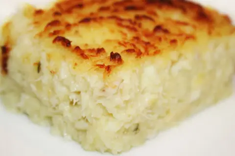 Un morceau de brandade de poisson gratinée, prêt à être dégusté. Une recette savoureuse et réconfortante.