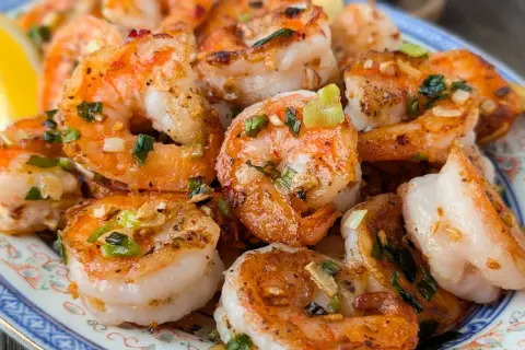 Crevettes sautées chinoises, parfumées à l'ail et à la ciboule, servies avec un quartier de citron. Un délice !