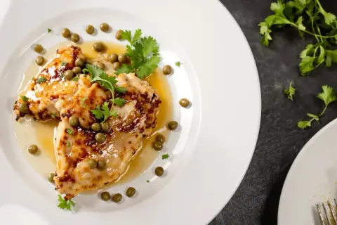 Délicieuse aile de raie poêlée, nappée d'une sauce citronnée et garnie de câpres et de persil frais. Un plat savoureux et léger.