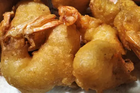 Gros plan sur des beignets de crevette dorés et croustillants, prêts à être dégustés.