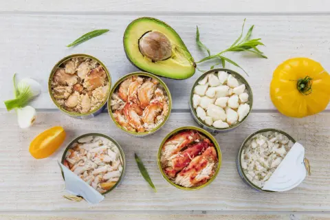 Six boîtes de crabe préparé pour la cuisson, avec avocat, tomate jaune et oignons verts.