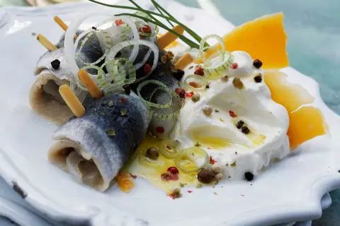 Délicieuse rollmops recette : harengs roulés, oignons, fromage et crème, assaisonnés de poivre et d'herbes.