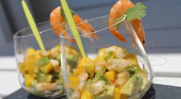 Verrine avocat saumon : deux coupes remplies d'un mélange coloré d'avocat, de mangue et de crevettes, garnies d'une crevette et d'une feuille de coriandre.