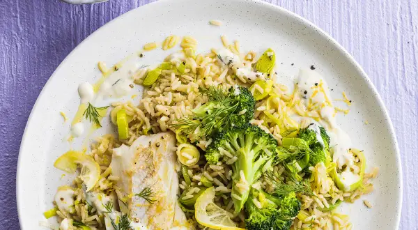 Poisson blanc avec riz, brocolis et poireaux, arrosé d'une sauce aneth crémeuse et garni de citron.
