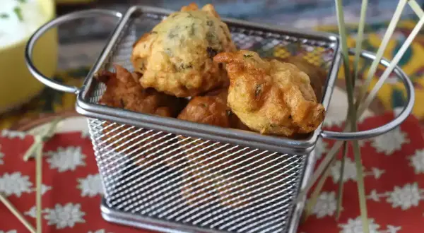 Accras de morue antillais dorés et croustillants dans une petite friteuse. Parfait pour une recette antillaise.