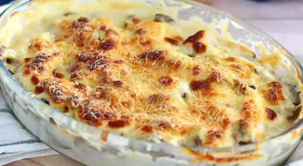 Un délicieux gratin de poisson crémeux, doré au four avec du fromage râpé, prêt à être dégusté.