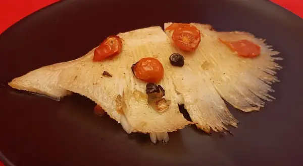 Aile de raie cuite à l'eau, garnie de tomates cerises et d'olives. Le temps de cuisson est parfait pour cette recette.