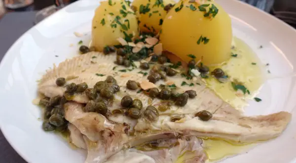 Une aile de raie à la plancha, servie avec des pommes de terre vapeur et une sauce aux câpres et persil. Un plat savoureux et léger.