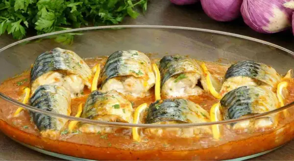 Maquereaux au four, tendres et savoureux, baignant dans une sauce tomate parfumée, accompagnés de quartiers de citron.