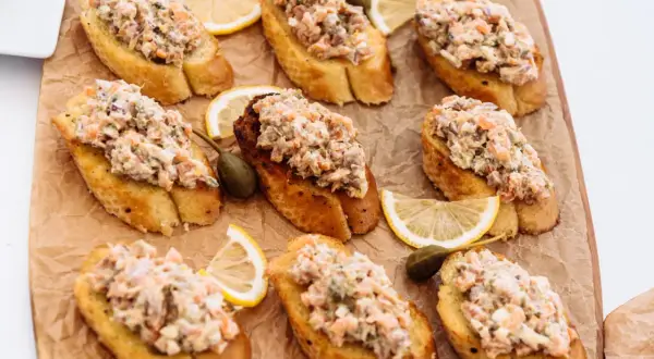 Bruschettas garnies de rillettes de sardines, câpres et quartiers de citron. Un délice pour l'apéritif.