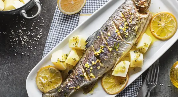 Poisson entier au barbecue, garni de citron et de pommes de terre. Un délice simple et savoureux.